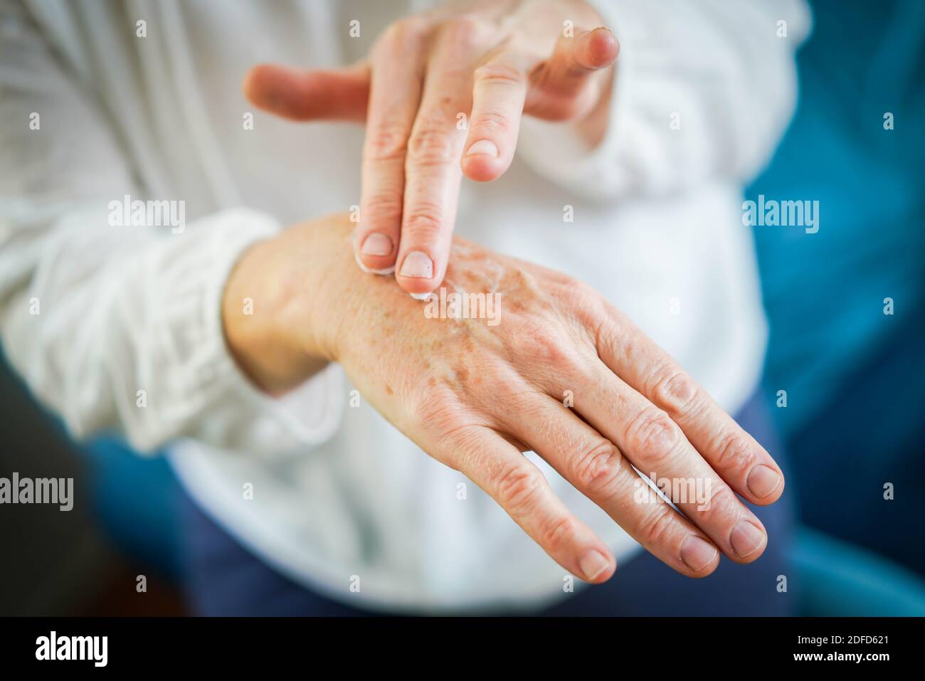 Woman applying cream on her hands. Stock Photo