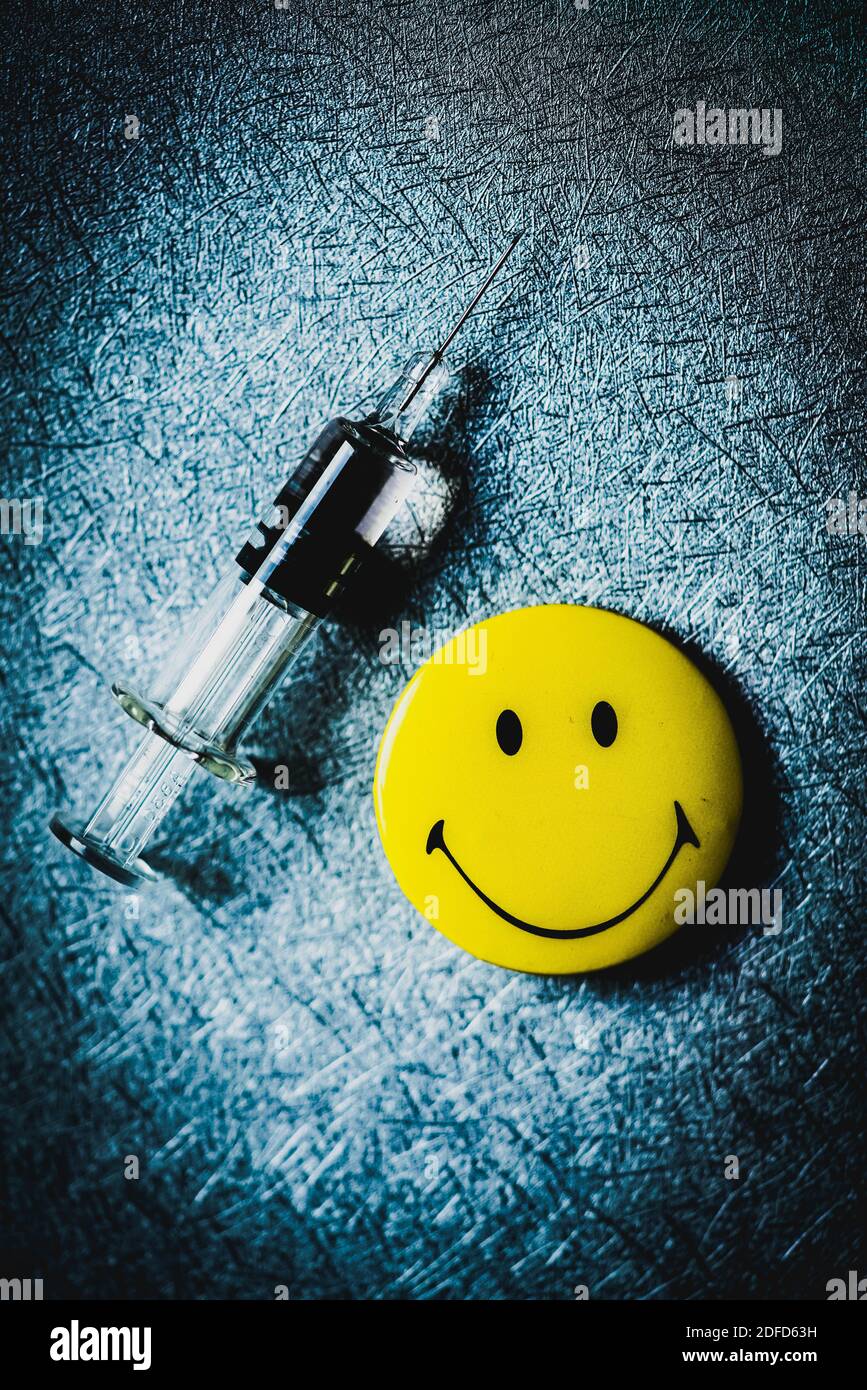 Vaccination syringe and smiley face symbol. Stock Photo