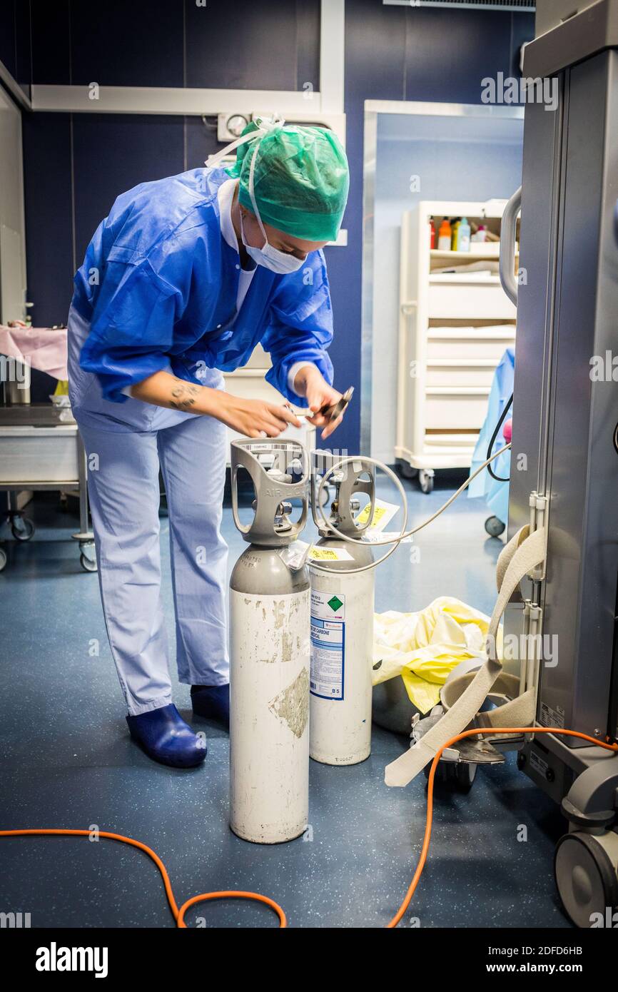 Nurse changing carbon dioxide gas cylinder during surgery, Bordeaux hospital, France. Stock Photo