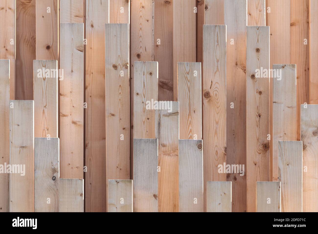 Vertical row of new wooden girders with different lenghts Stock Photo