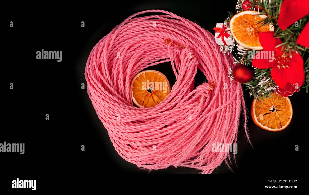 Synthetic pink kanekalon braids - Christmas photo with decoration on black. New Year photo for a store or hairdressing salons, barbershops Stock Photo