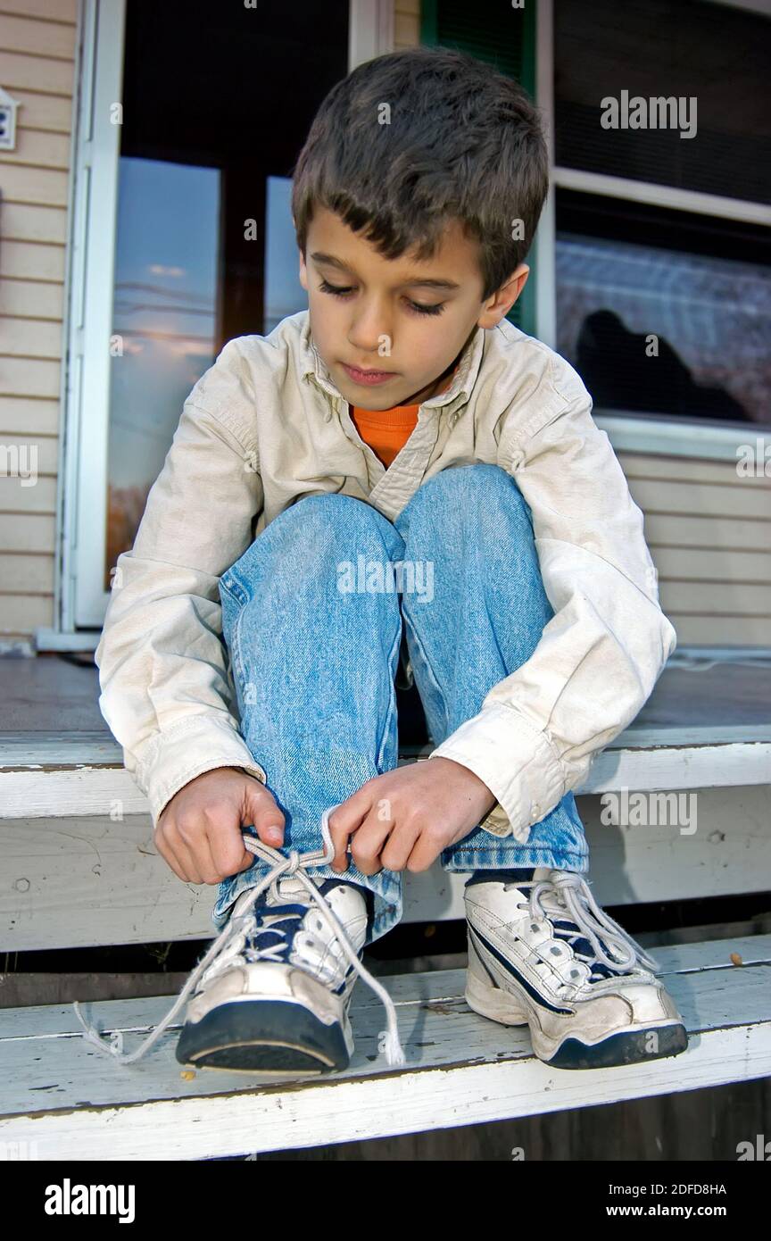 Boy learns to tie his shoe Stock Photo Alamy