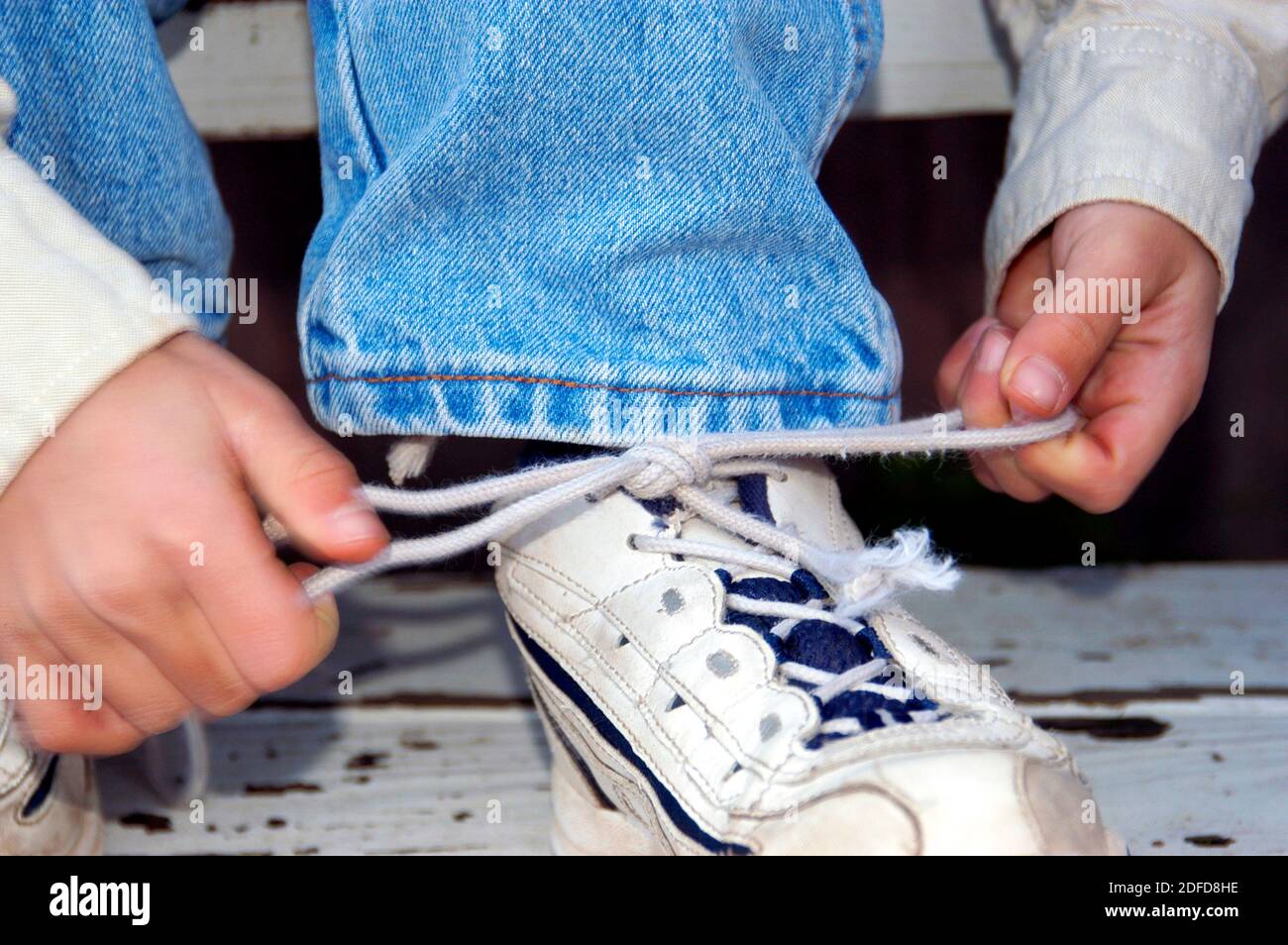 Four year old boy learning to tie shoe laces Stock Photo