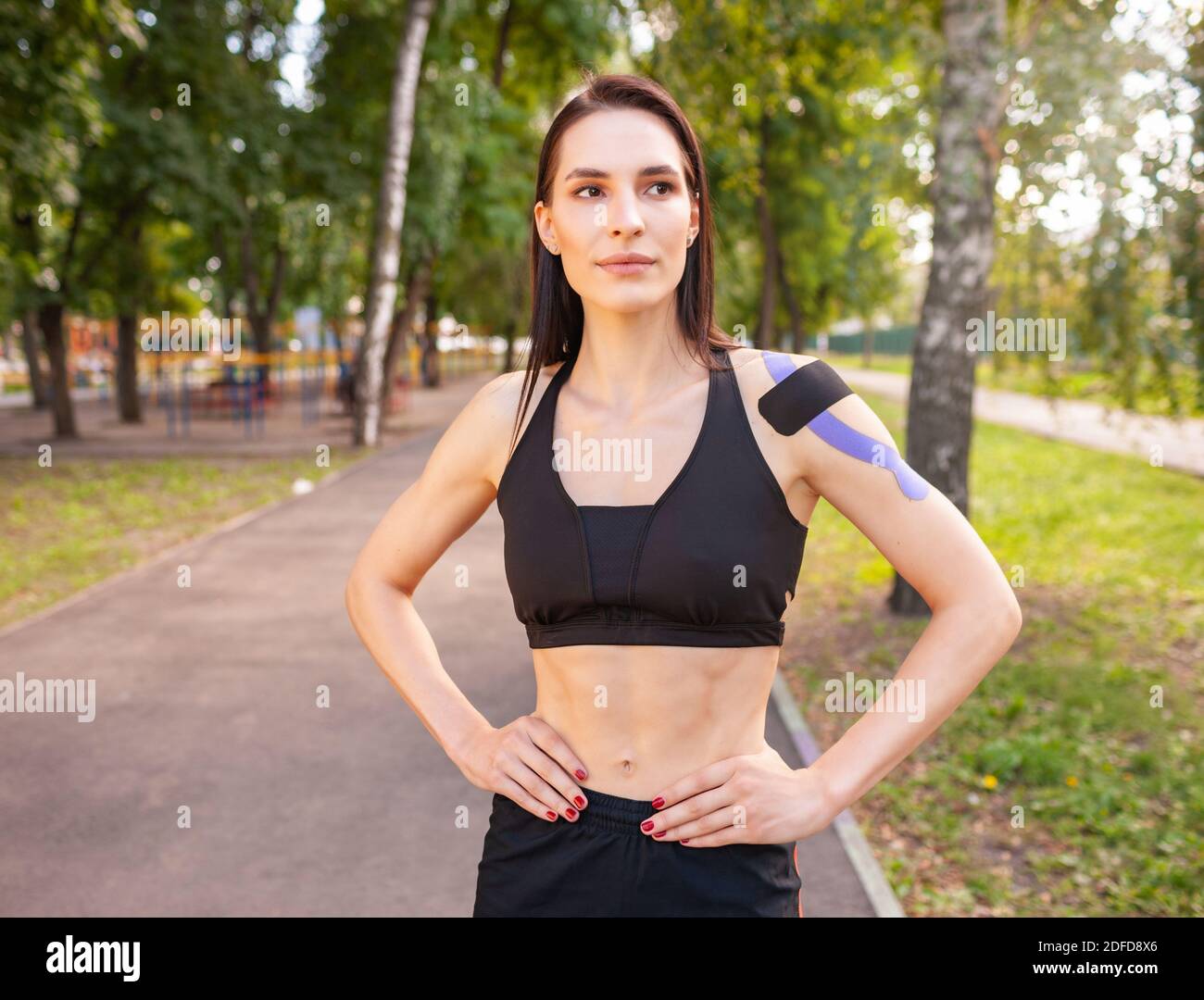 Portrait of attractive muscular brunette woman wearing black sports ...