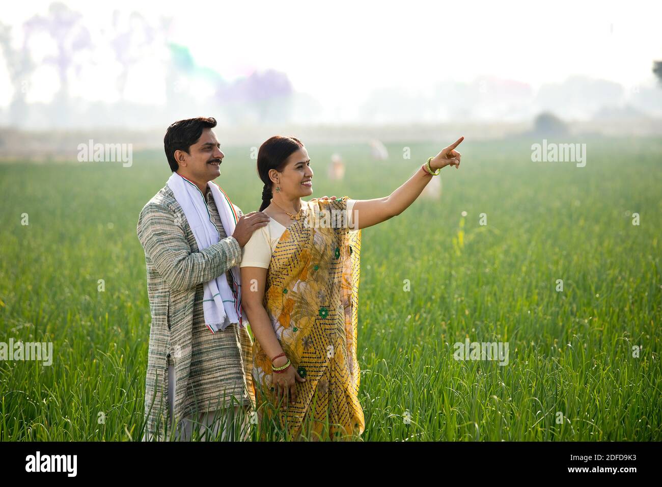 Happy Indian couple farmers examining crop in agricultural field Stock ...