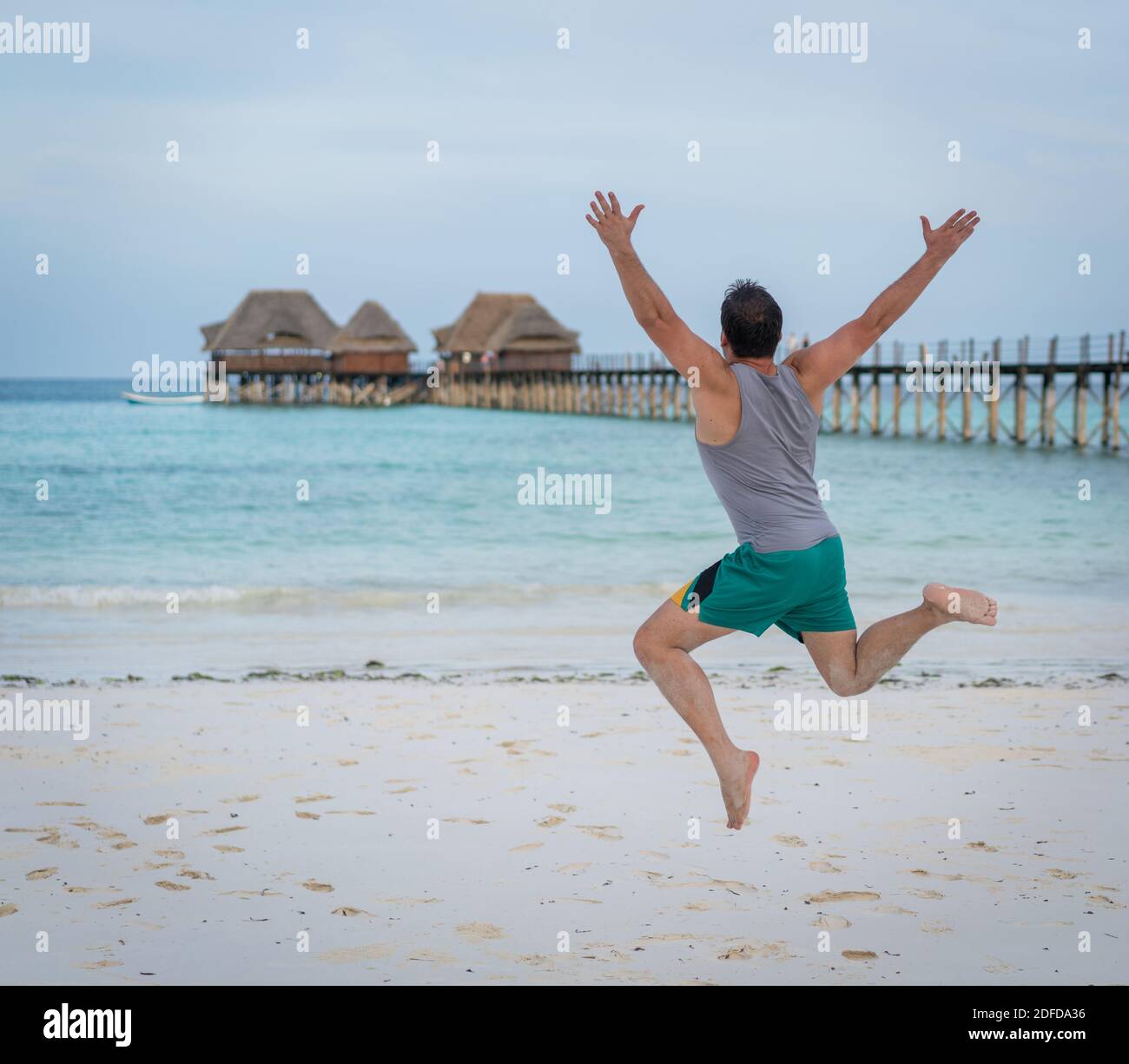 Jumping man on tropical beach Stock Photo