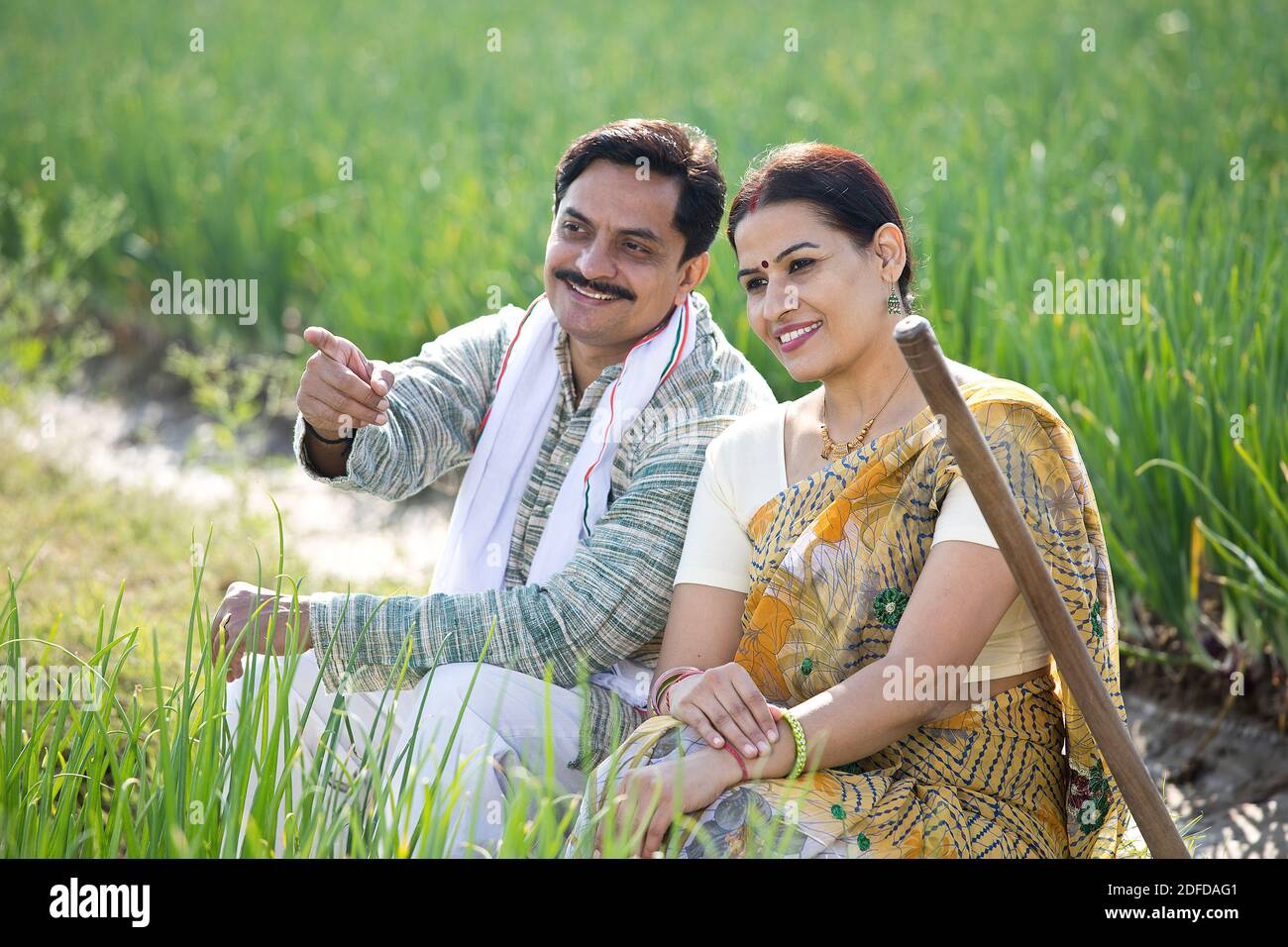 Happy Indian couple farmers examining crop in agricultural field Stock ...