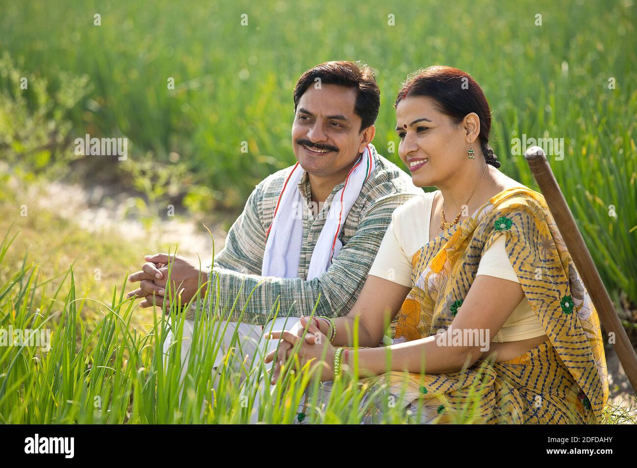 Happy Indian couple farmers examining crop in agricultural field Stock ...