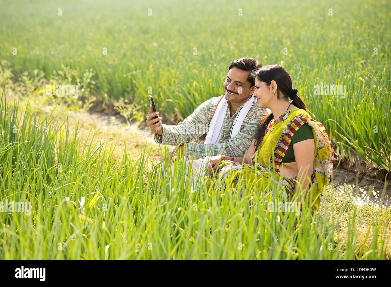 Happy Indian couple farmers examining crop in agricultural field Stock ...