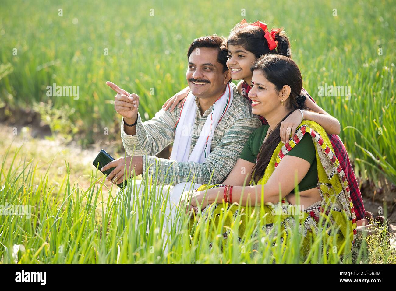 Happy family of farmer in agricultural field Stock Photo - Alamy
