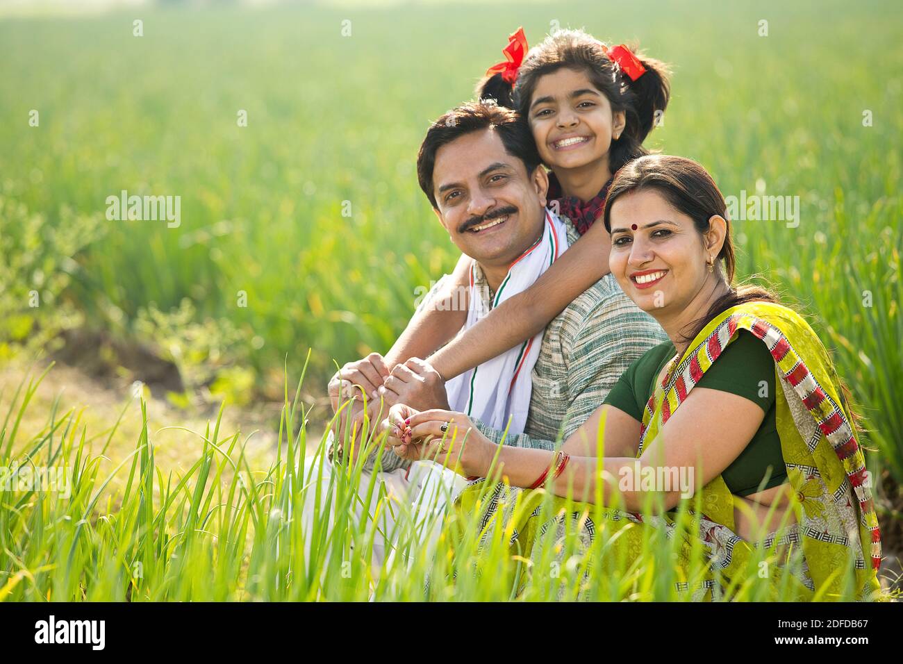 Happy family of farmer in agricultural field Stock Photo - Alamy