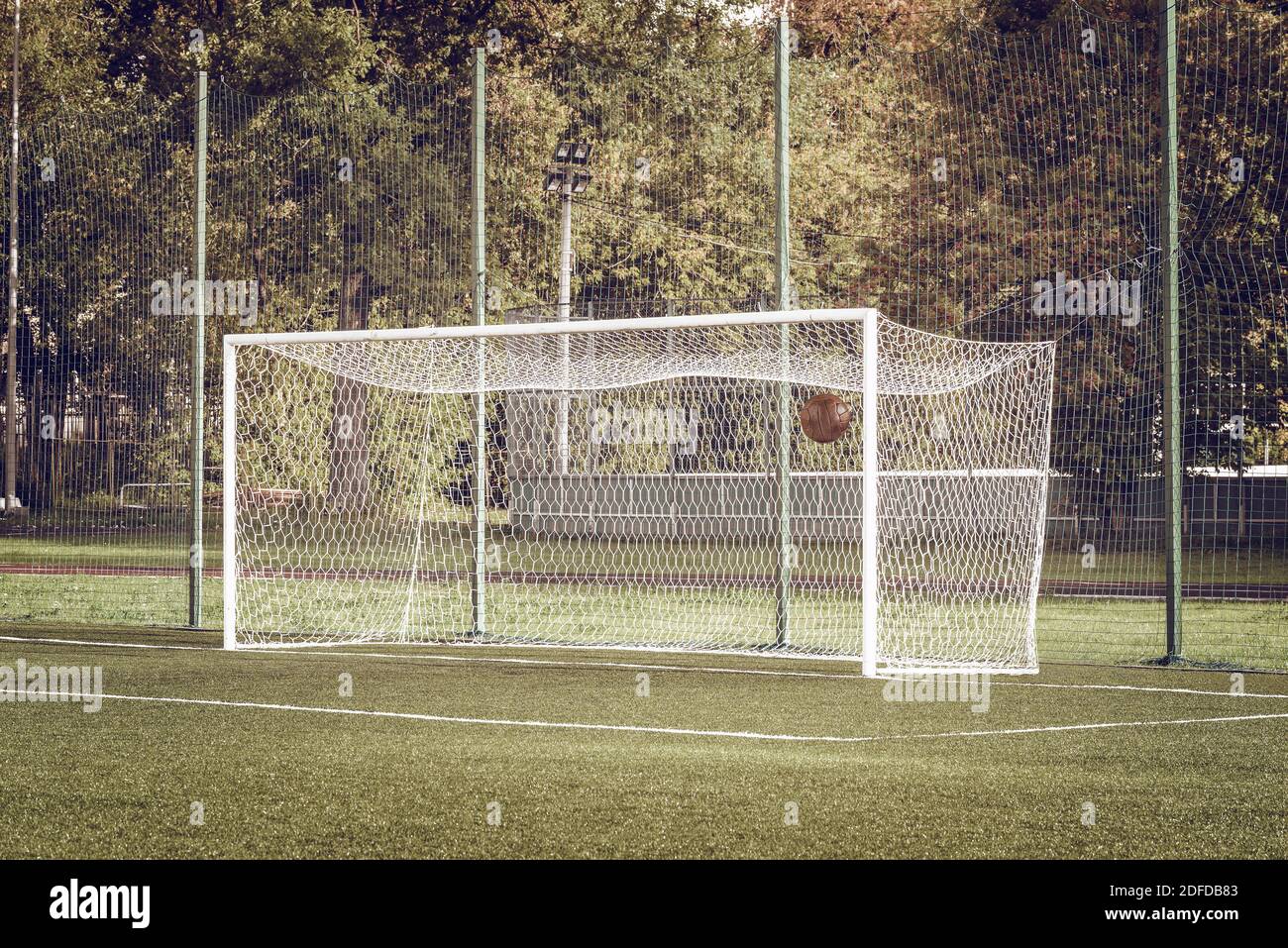 View of the football gate and ball inside it by soccer the field Stock Photo