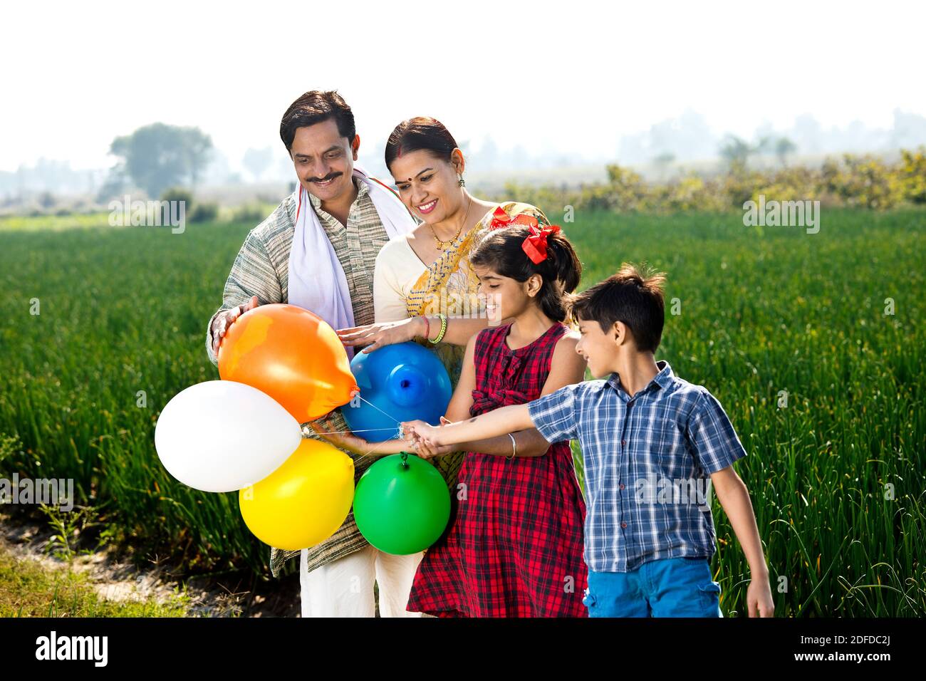 Happy indian family of farmer with balloons in agricultural field Stock ...