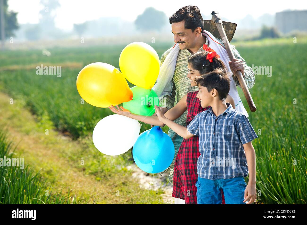 Happy family of farmer with balloons in agricultural field Stock Photo ...
