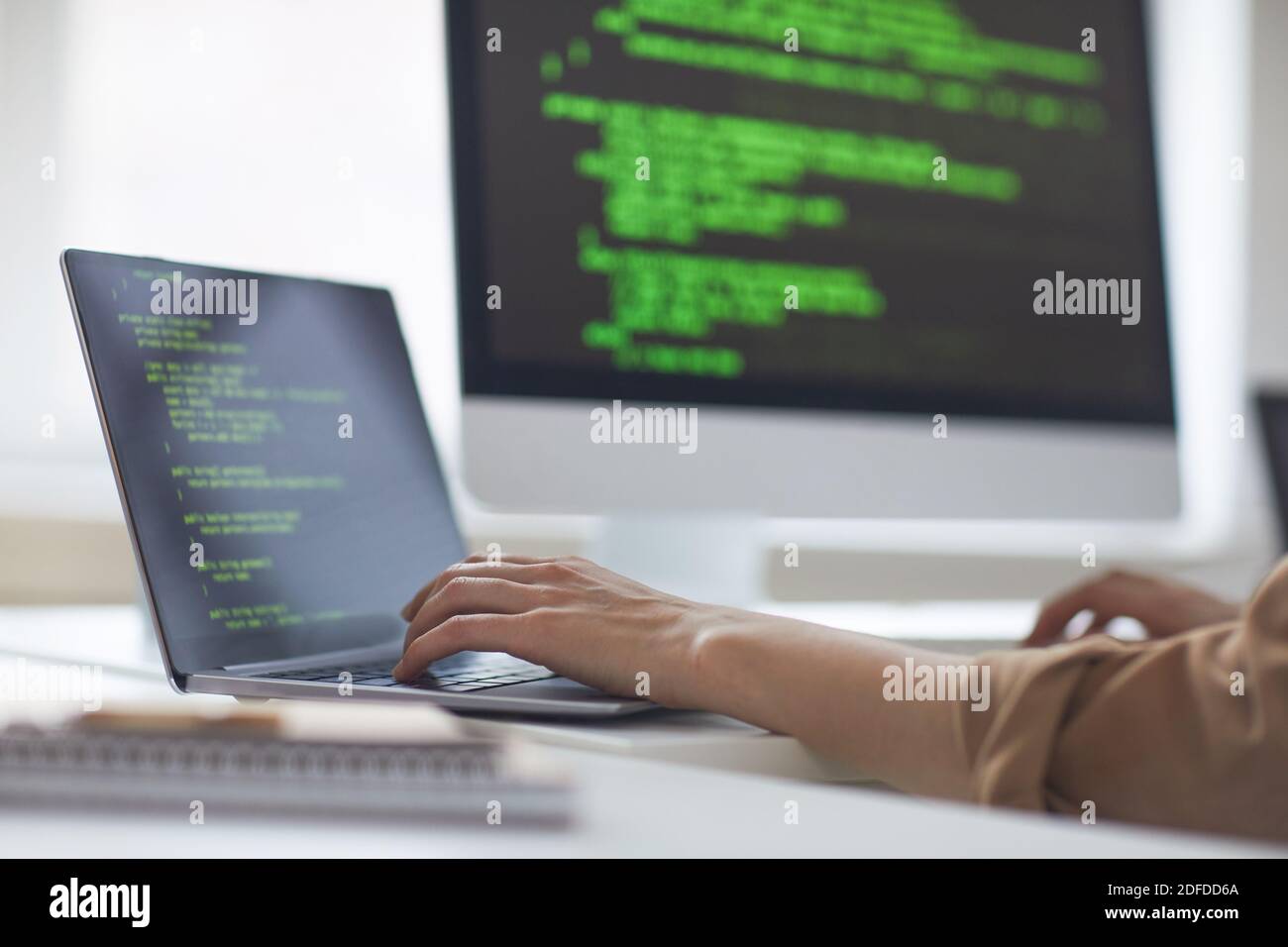Close-up of developer developing new program while typing on laptop at the table at office Stock Photo