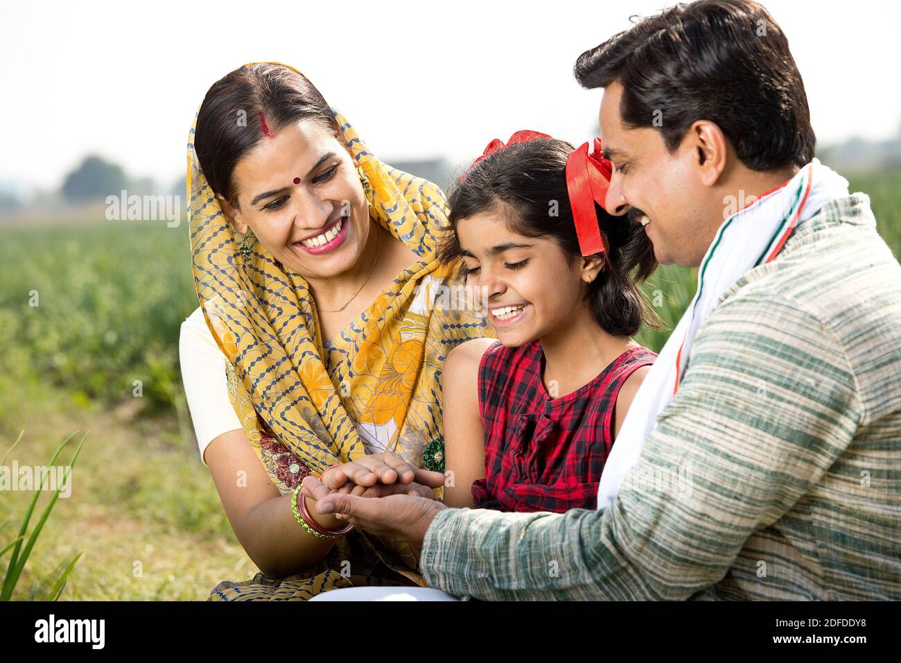 Happy family of farmer in agricultural field Stock Photo - Alamy