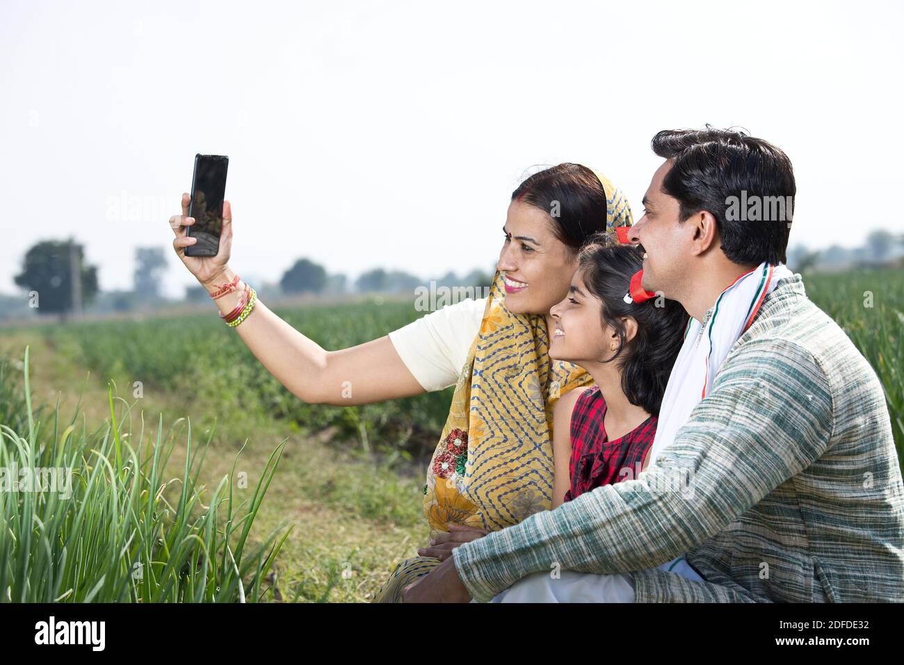 Happy indian family of farmer in agricultural field using phone Stock ...