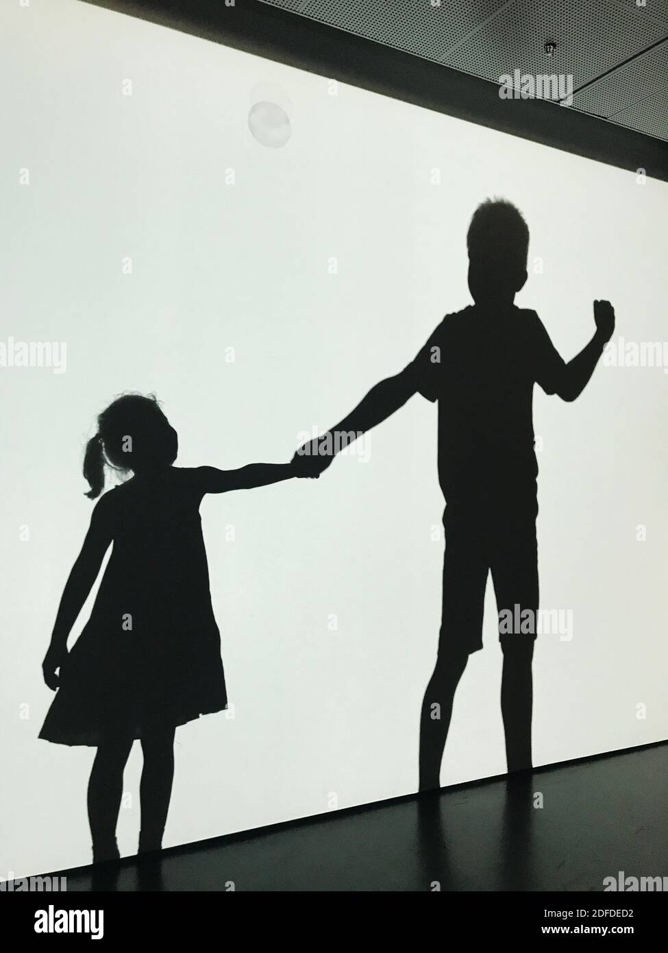 Friendship concept, silhouettes of a boy and a girl holding hands Stock Photo