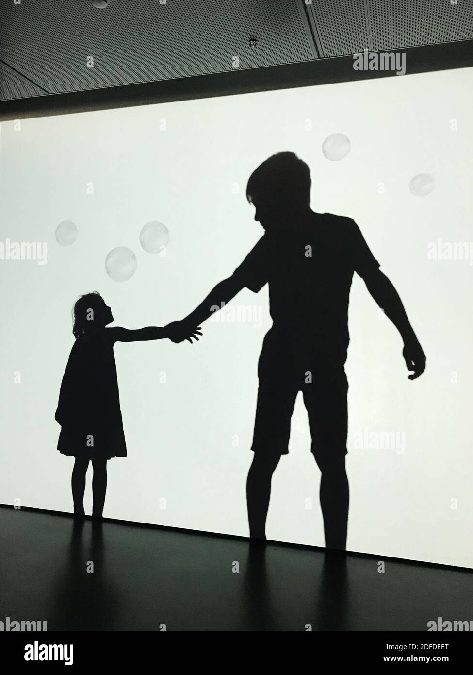 Friendship concept, silhouettes of a boy and a girl holding hands Stock Photo