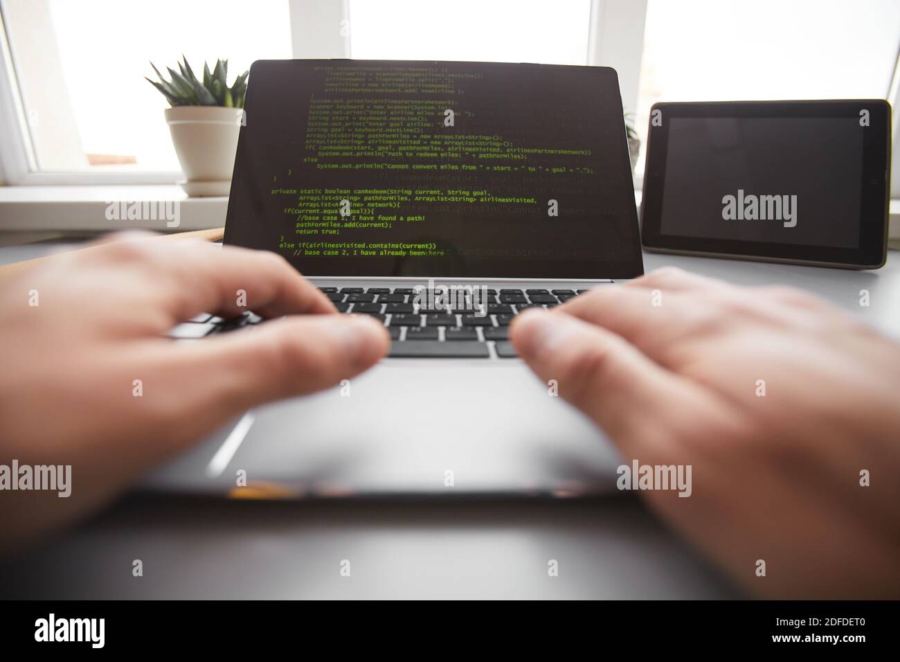 Close-up of programmer typing on laptop programming new system for ...