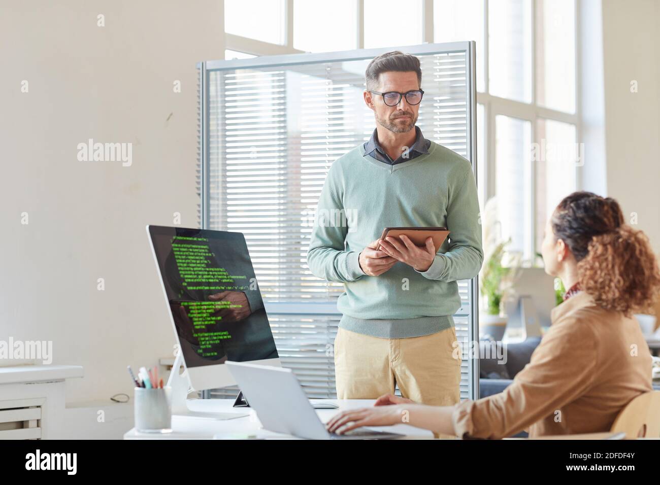 Two business colleagues using digital tablet and computers in their work at office Stock Photo