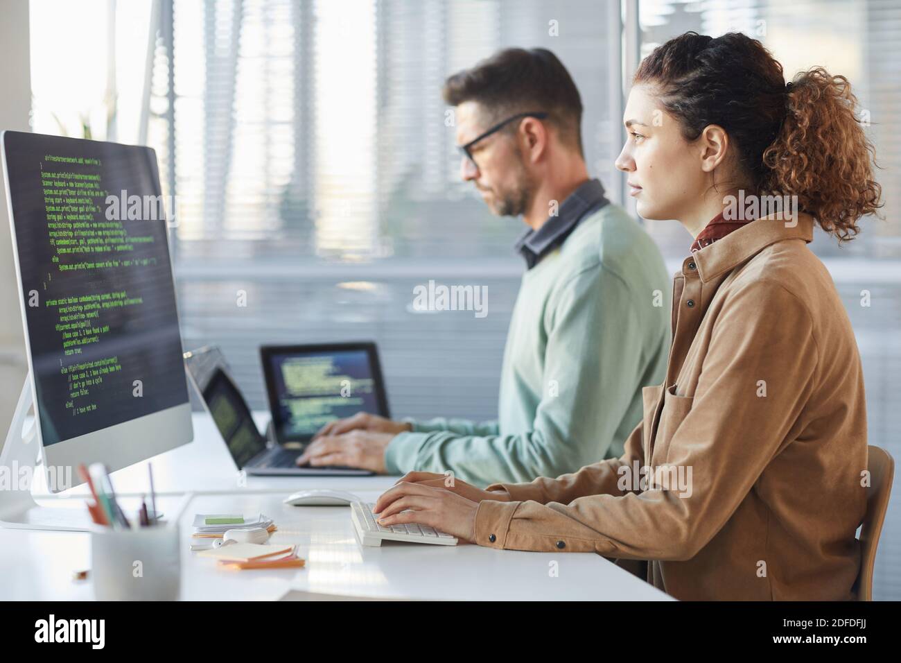 Programmers working on computer in IT office typing data coding in software Stock Photo