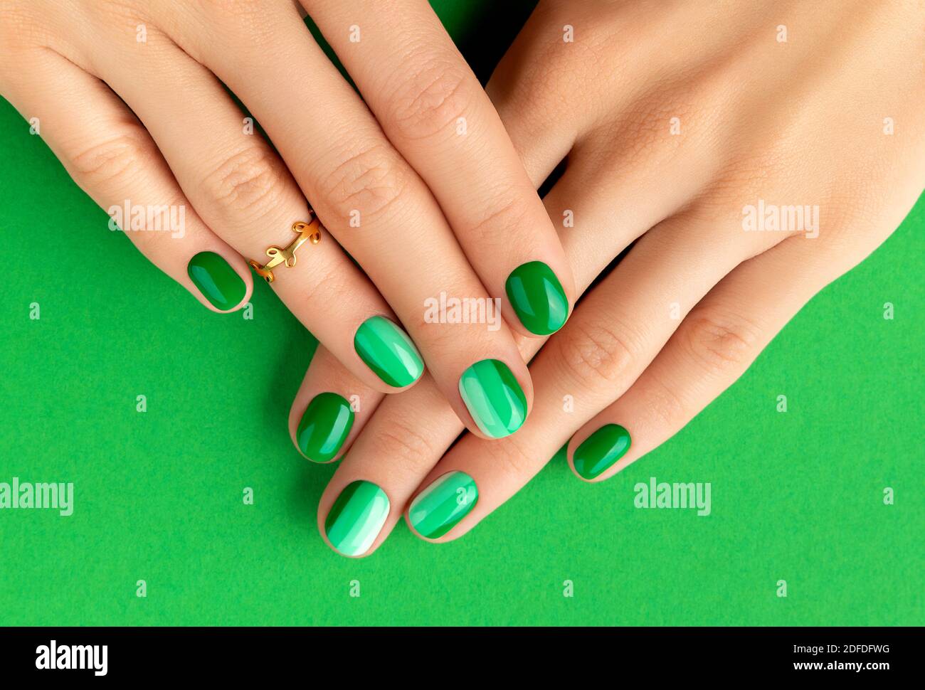 Beautiful groomed woman's hands with spring summer nail design on green  background Stock Photo - Alamy