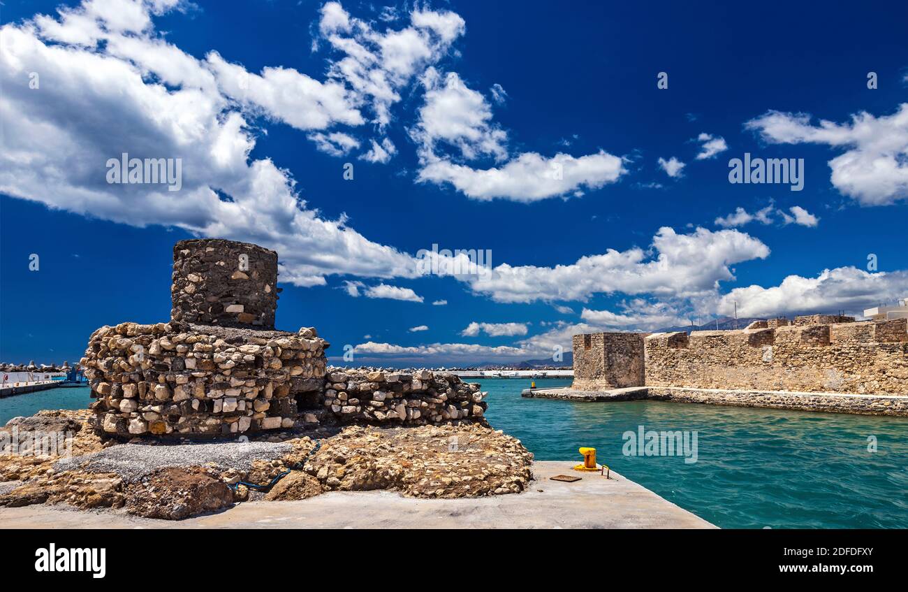 The entrance of the old harbor of Ierapetra town (Crete island, Greece), with an old lighthouse, to the left and Kales castle to the right. Stock Photo