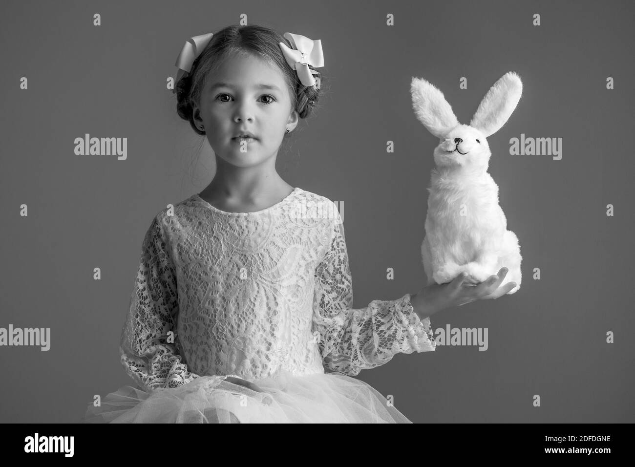 A GIRL AND HER STUFFED RABBIT, CHILD AND PET, STUDIO PORTRAIT Stock Photo