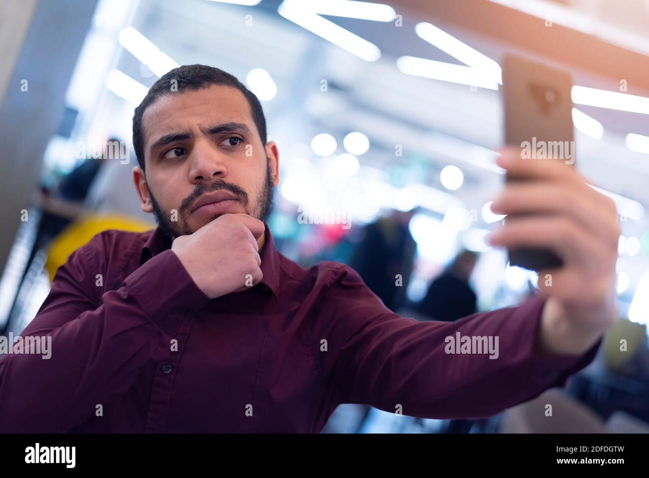 Smiling young african  man using smartphone in a modern cafe Stock Photo