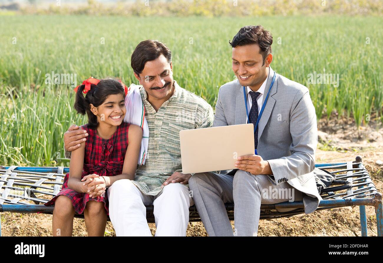 Farmer with businessman using laptop on agriculture field Stock Photo