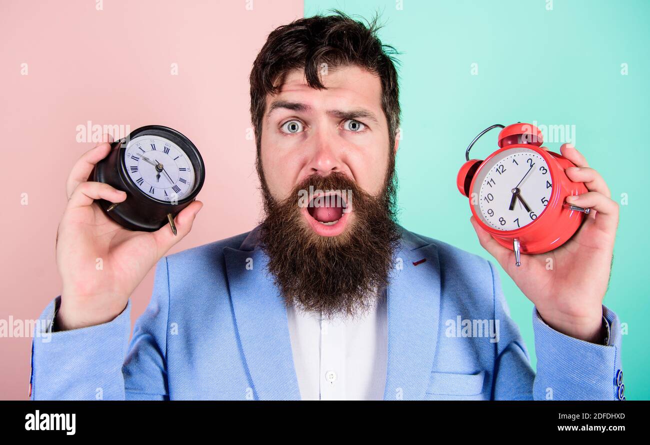 Does changing clock mess with your health. Man bearded hipster hold two
