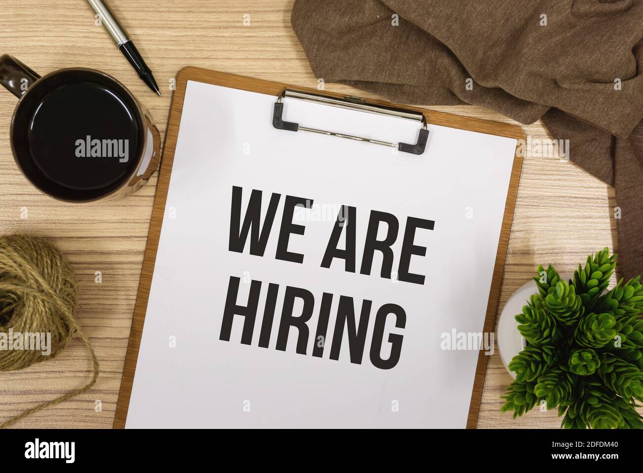 Overhead View of We Are Hiring Announcement on Clipboard Stock Photo