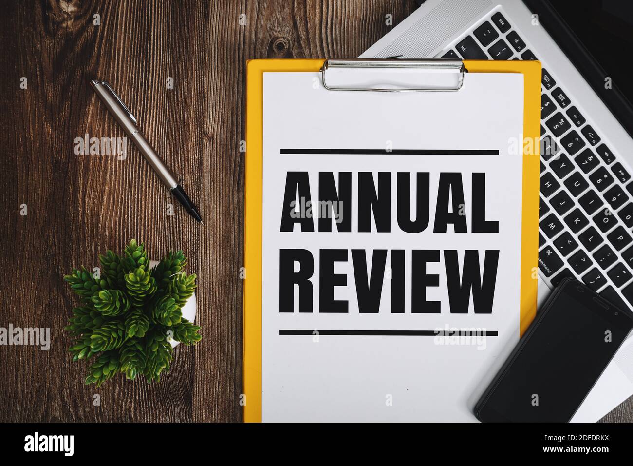 Annual Review on Clipboard over Wooden Work Desk Stock Photo