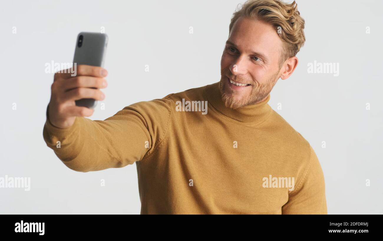 Attractive smiling bearded man wear turteneck taking selfie on ...