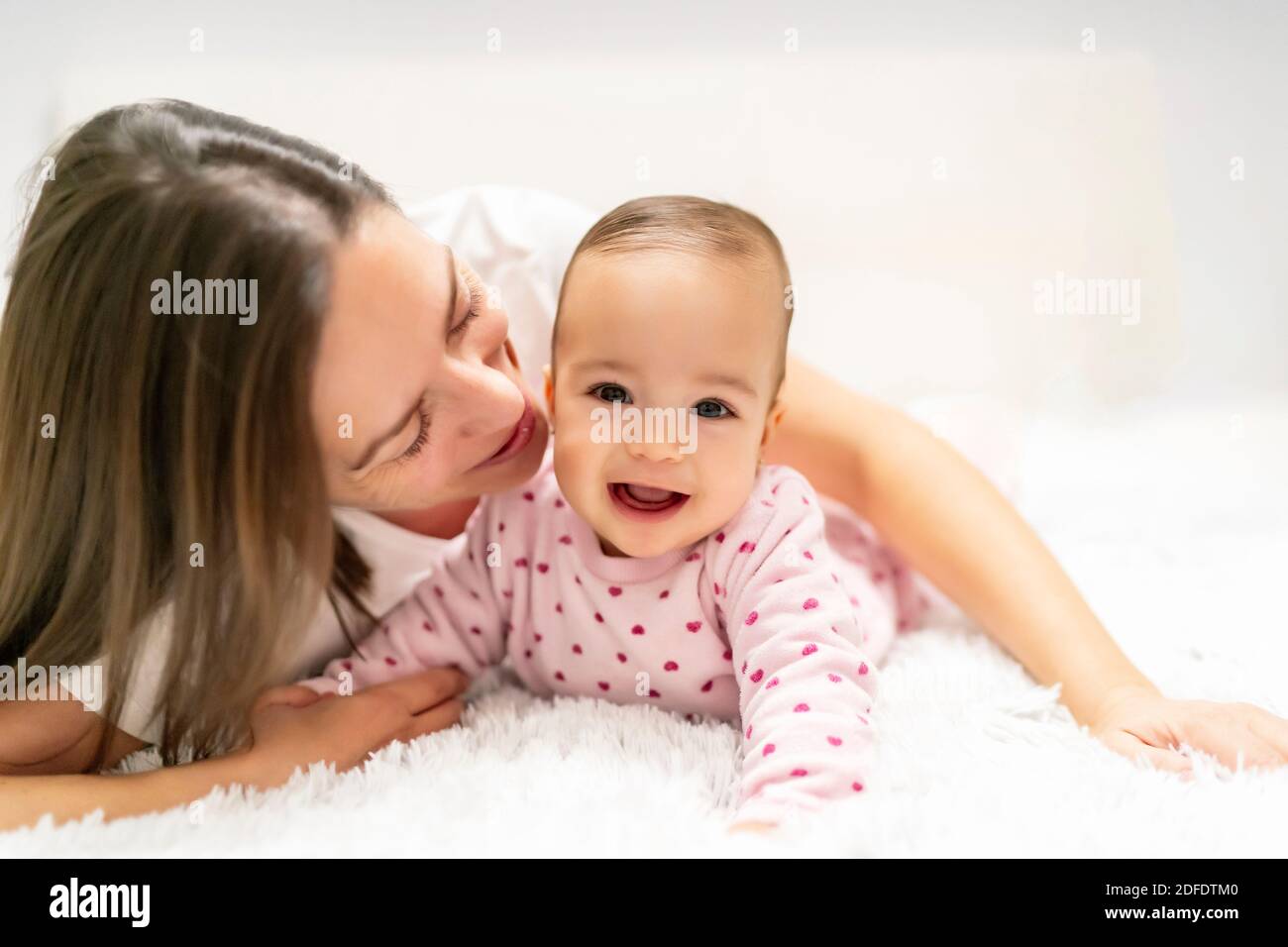 mother kissing her little daughter Stock Photo