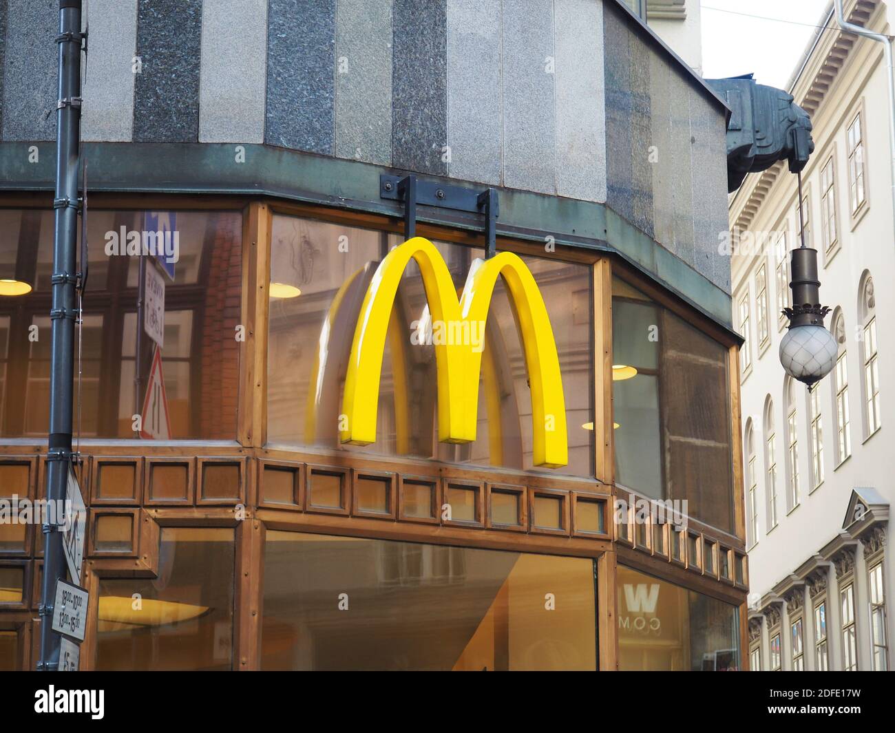 Budapest, Hungary - November 3, 2020: Yellow curved Mc Donald's logo sign on the facade of a Mac Donald restaurant in Budapest downtown Stock Photo