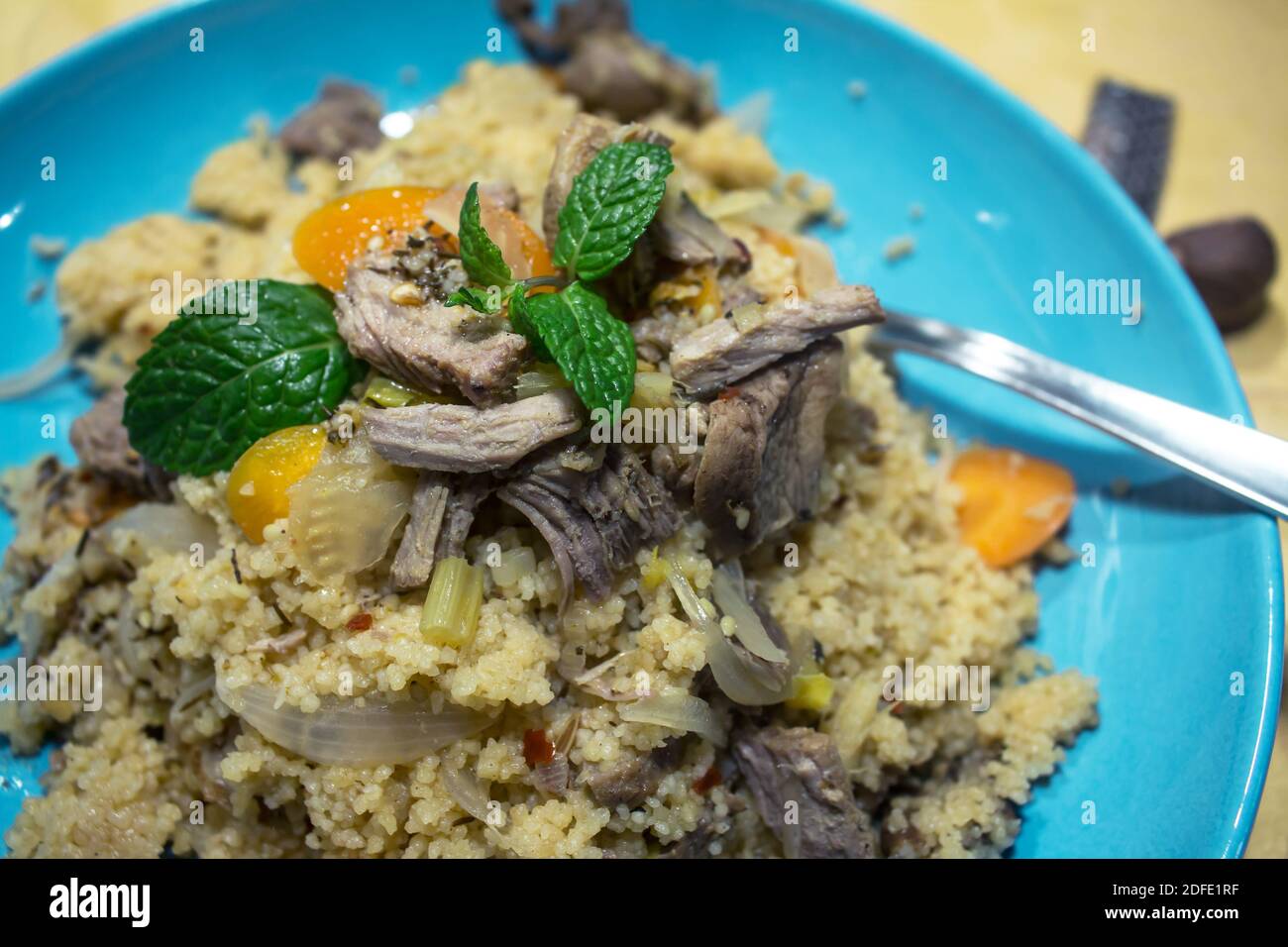 Couscous made from turkey meat and vegetables in a blue dish Stock