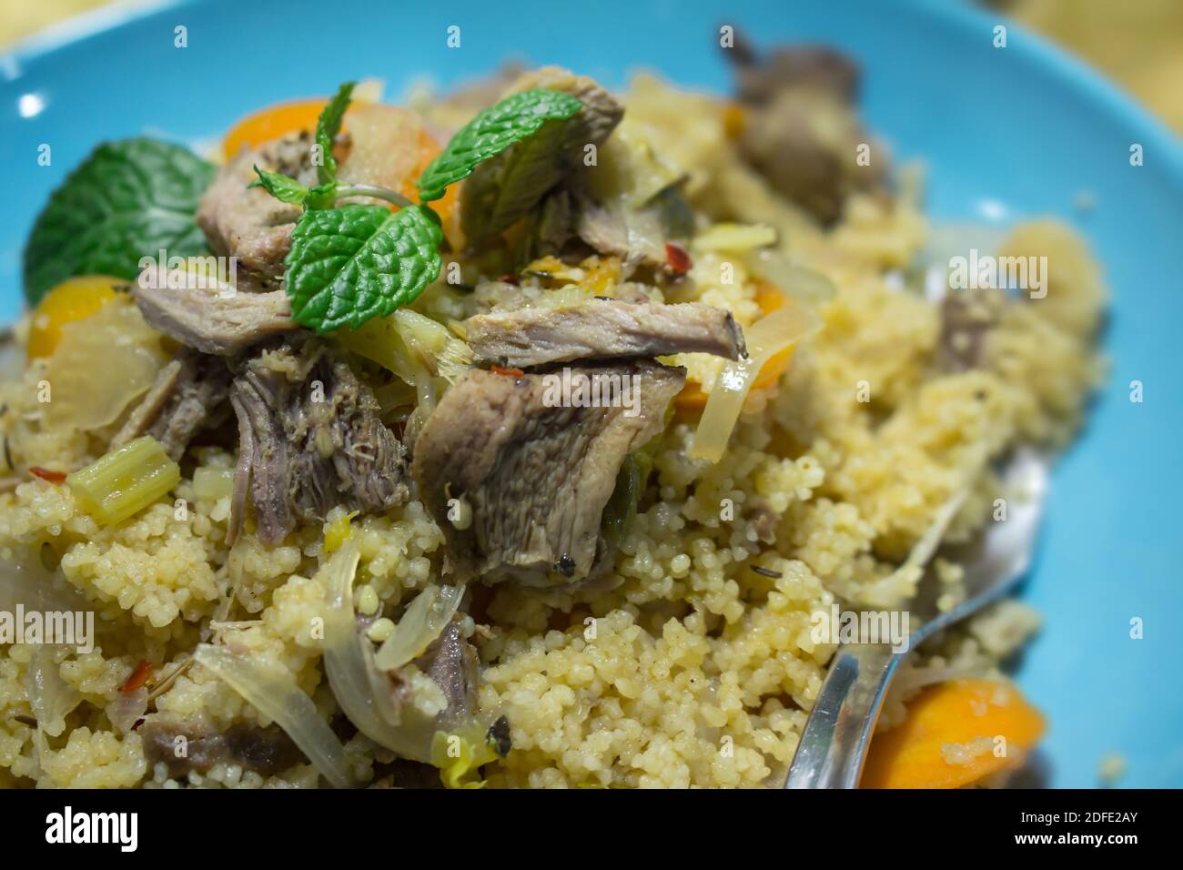 Couscous made from turkey meat and vegetables in a blue dish Stock