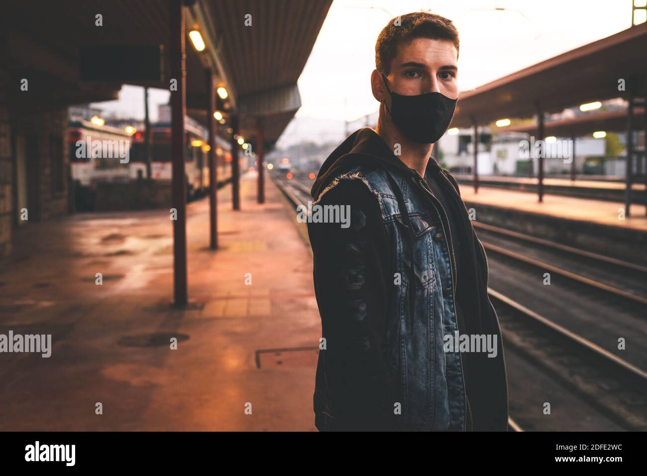 Young man waiting at the train station Stock Photo Alamy