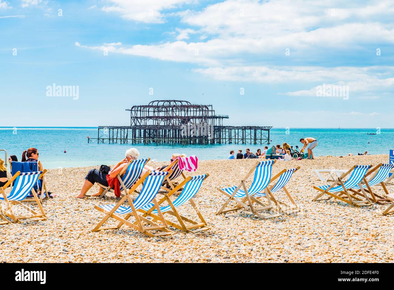 People relaxing at the beach next to the Brighton West Pier. Brighton, East Sussex, England, United Kingdom, Europe Stock Photo