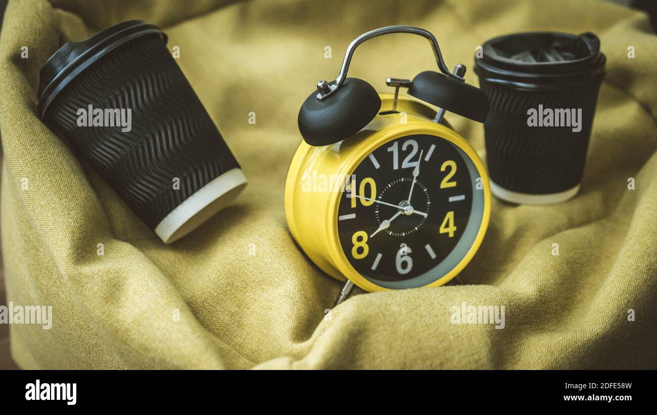 Coffee in a plastic cup with retro clock and alarm clock,close-up. Stock Photo
