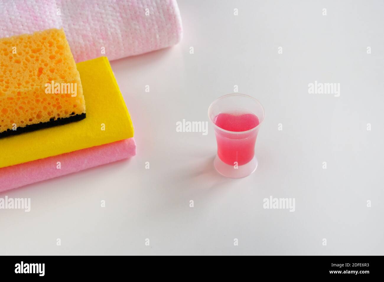 Cleaning concept. Detergent for cleaning room. Measuring plastic cup with pink liquid cleaning