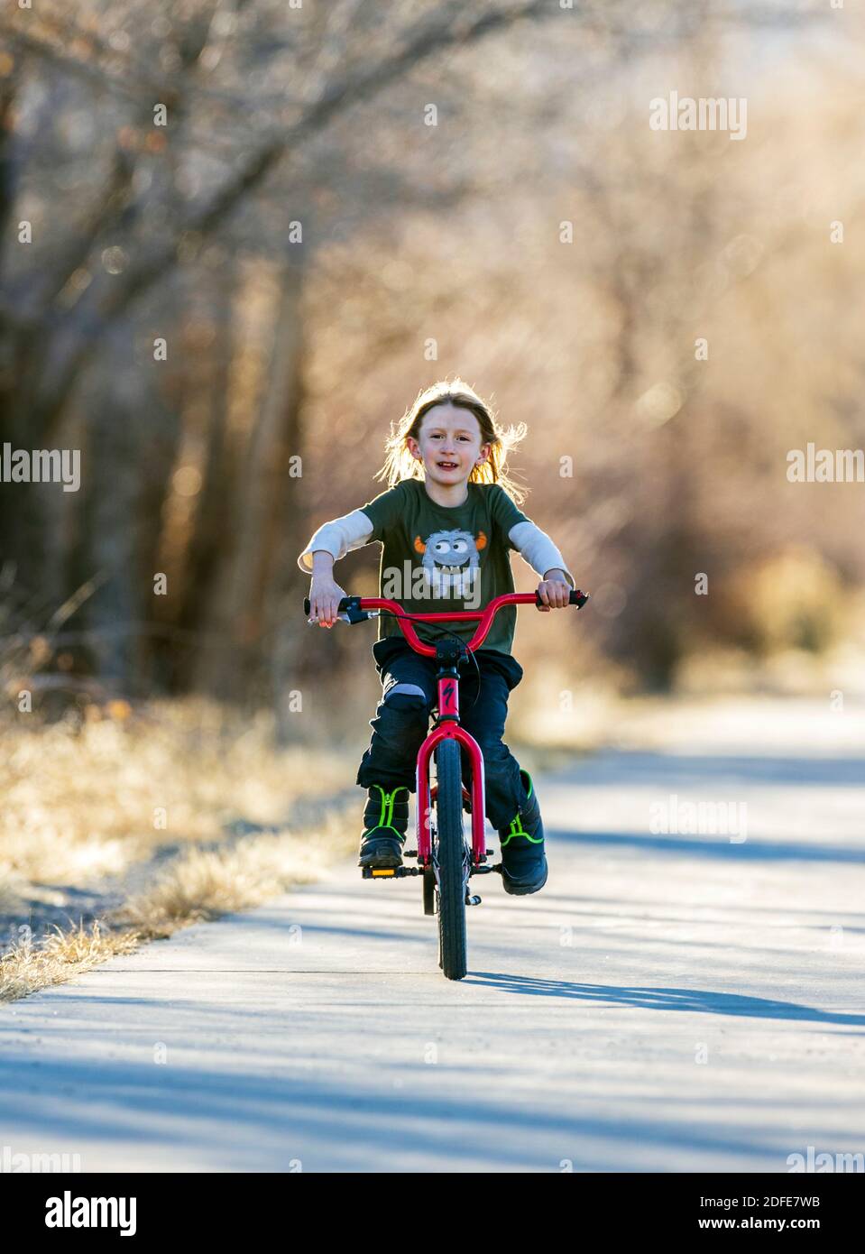 Happy young boy riding his bike on a paved trail; Salida; Colorado; USA Stock Photo