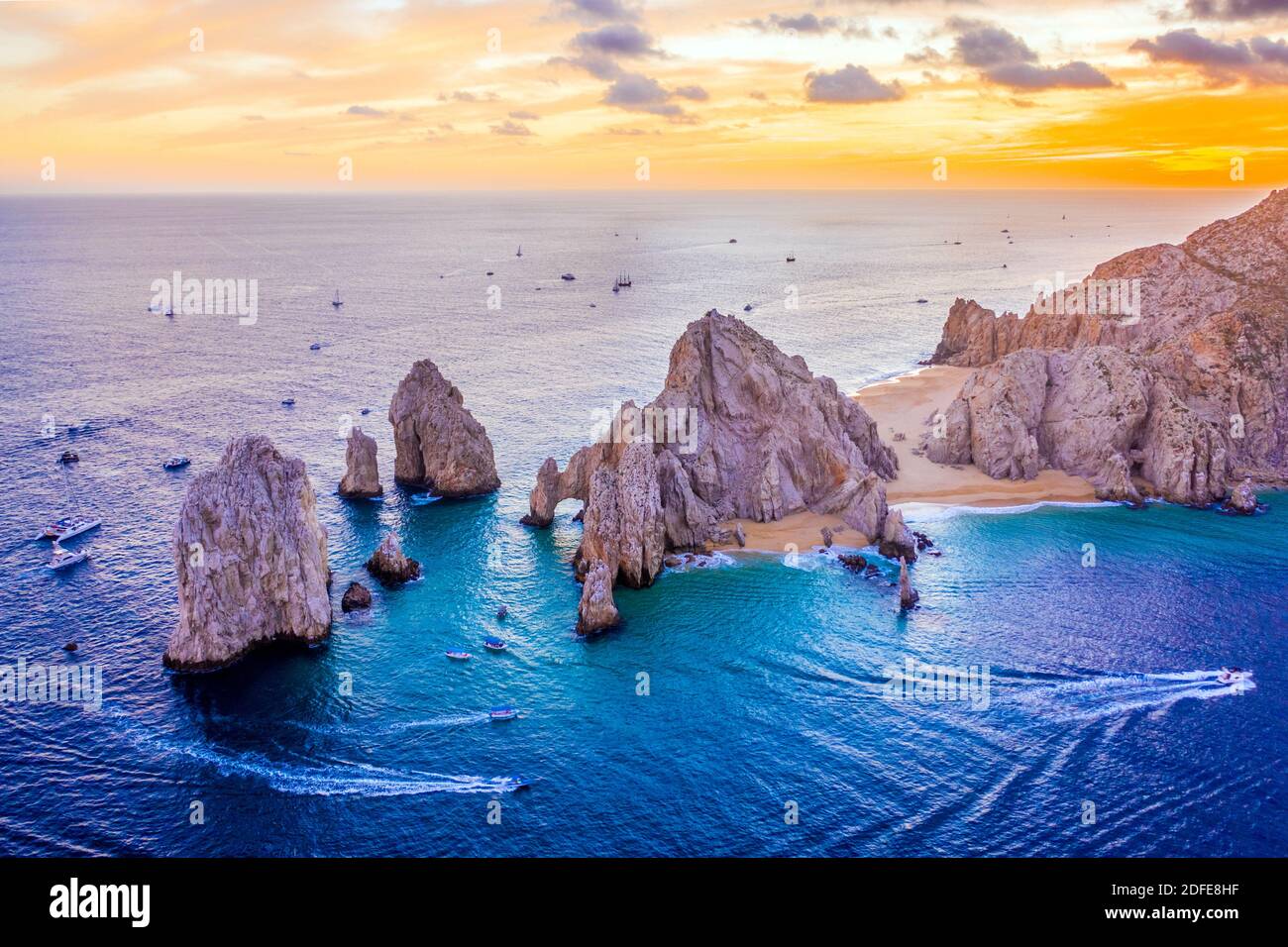 Aerial view of boats speeding by El Arco de Cabo San Lucas, Mexico at sunset, Baja California Sur Stock Photo