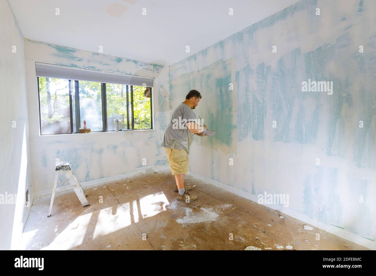 Work hand tool wall using plastering tool for unfinishing wall Stock Photo
