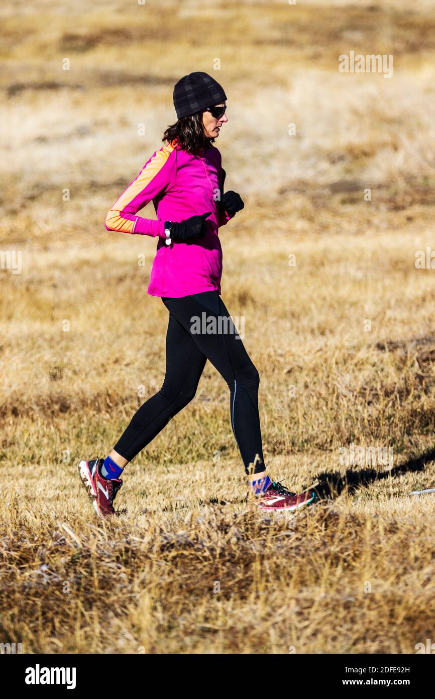 Woman trail running on clear winter day; Vandaveer Ranch; near Salida; Colorado; USA Stock Photo
