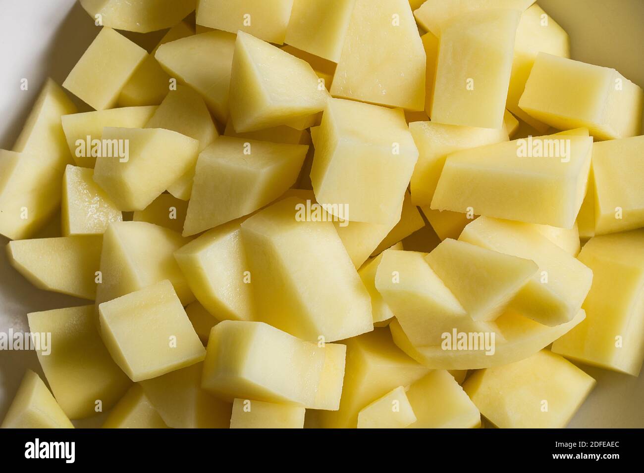 A bowl is filled with chopped raw potatoes. Organic texture as a background. Stock Photo