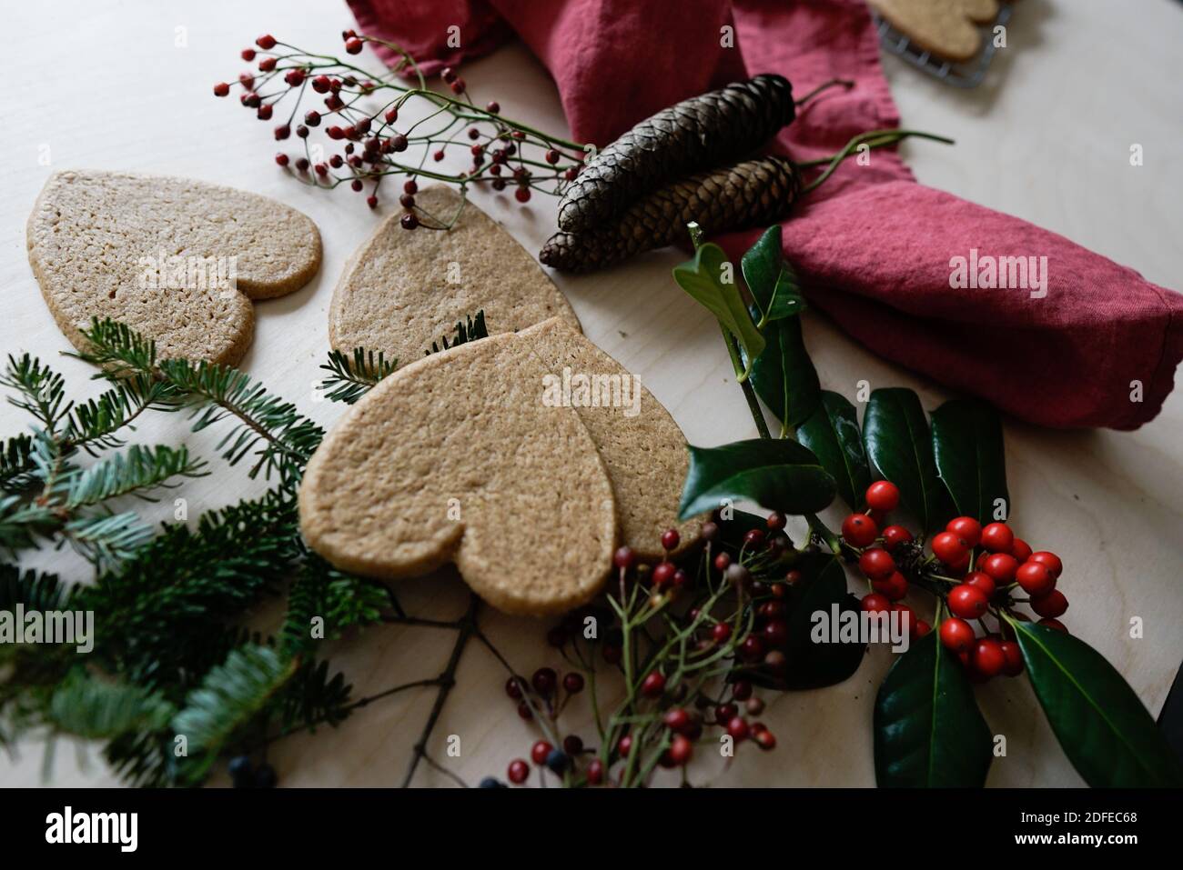 Arrangement of holiday objects and decorations -- green spruce, red berries, ginger heart cookies. Stock Photo