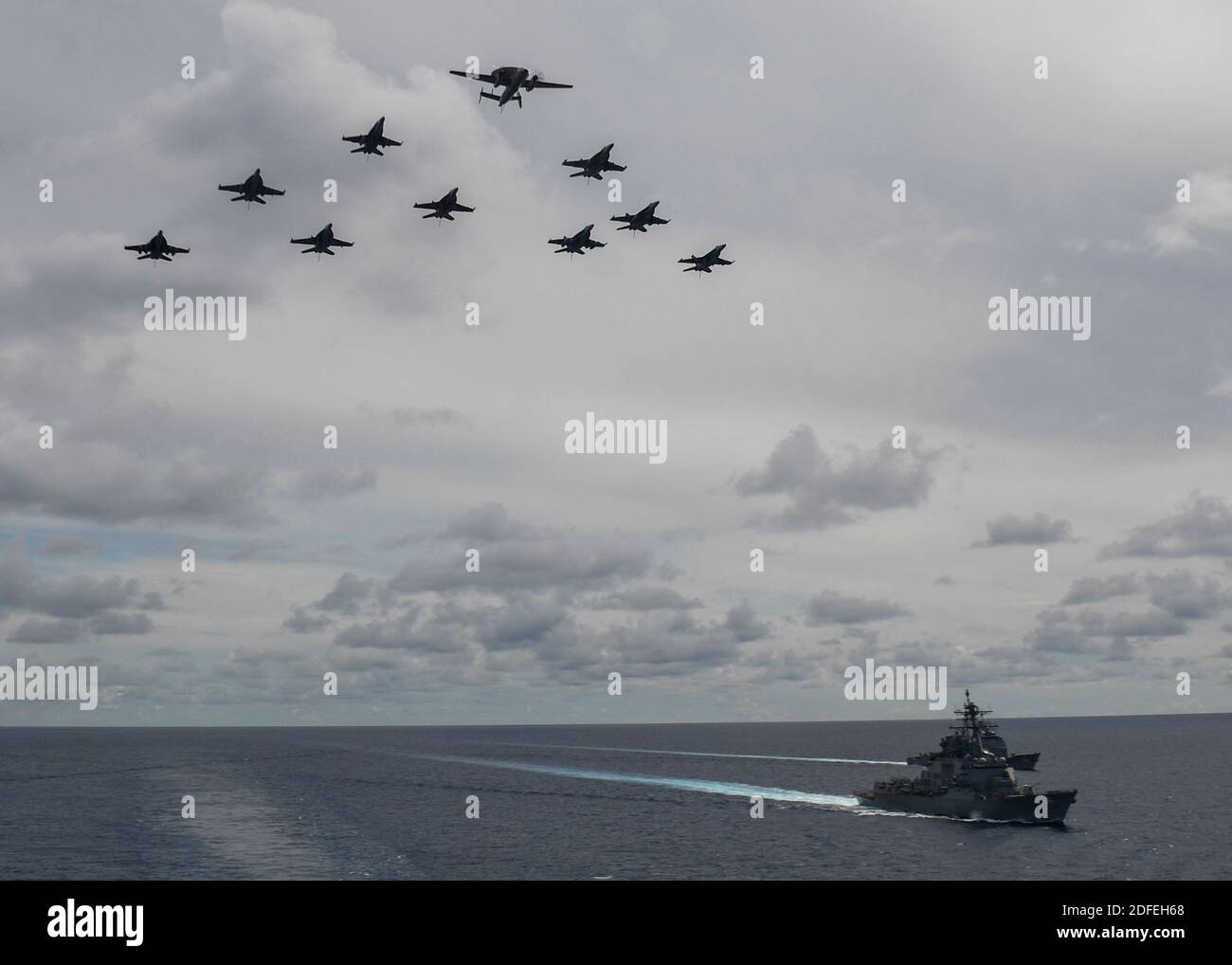 Hand out photo dated July 6, 2020 of Aircraft from Carrier Air Wings 5 and 17 fly in formation over the guided-missile destroyer USS Ralph Johnson (DDG 114), front, and the guided-missile cruiser USS Princeton (CG 59), part of the Nimitz Carrier Strike Force. For the first time in six years, two US Navy aircraft carriers are in the South China Sea. The two US carriers arrived in the region as China wrapped up its own set of naval exercises near a disputed island chain. Beijing's state media carried reports boasting of the country's readiness to repel any US attempt to challenge its claims. U.S Stock Photo